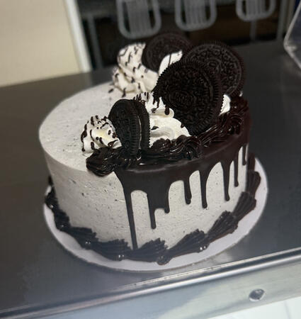 Chocolate cake, Iced and Filled with cookies and cream whipped cream, chocolate drip, Fudge borders, oreo decoration